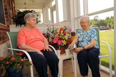 Two elderly ladies smiling and laughing together