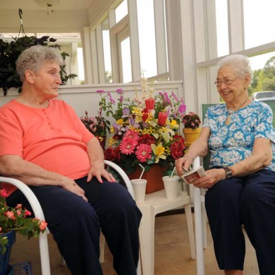Two elderly ladies smiling and laughing together