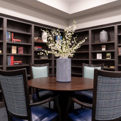 built-in book shelves with books next to round dining table and chairs