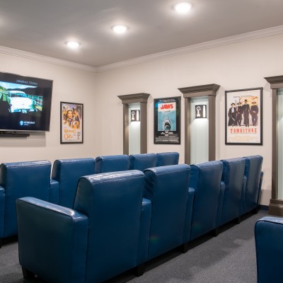 theater room with large blue chairs facing large tv