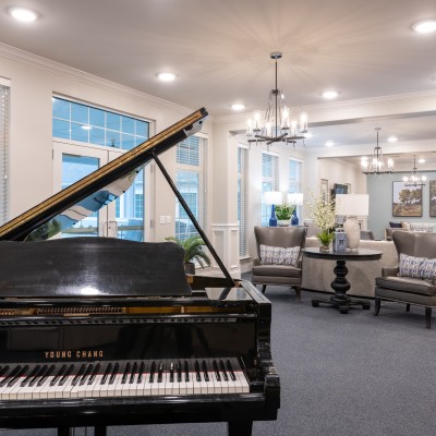 grand piano in large white room with high ceilings